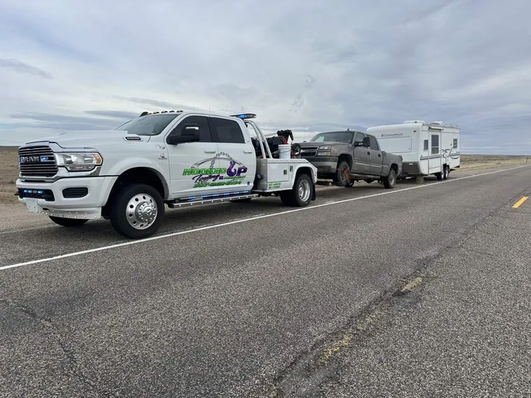 Truck and fifth wheel camper towed on the highway by Hooked Up Towing in Wyoming